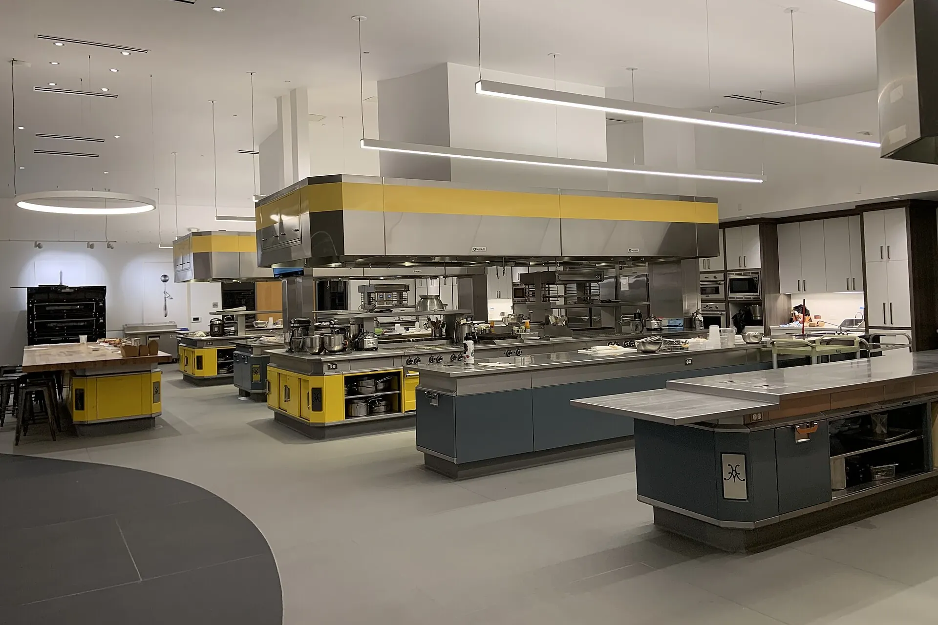 Cocina comercial limpia con estaciones de cocción de acero inoxidable e islas de preparación