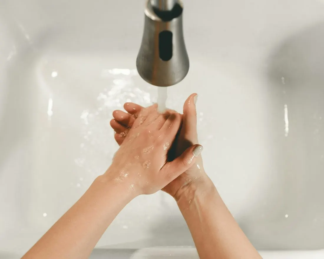 Manos lavándose bajo el chorro de agua de la llave